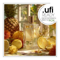 Butelka perfum otoczona pomarańczami i innymi owocami, tworząca świeży i owocowy klimat.