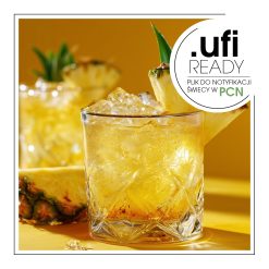 Napój ananasowy z plasterkiem ananasa na wierzchu.