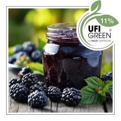 Słoik jeżynowej konfitury wśród świeżych owoców.