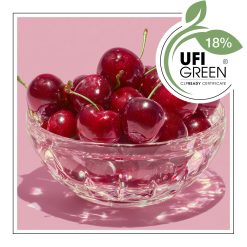 Wiśnie w szklanej paterze na różowym tle.