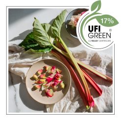 Patyczki rabarbaru leżące na białej tkaninie obok talerza z różowymi płatkami. - AF70 7915