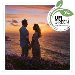 Para trzymająca się za ręce na klifie o zachodzie słońca nad oceanem, otoczona kwitnącymi kwiatami - AF70 0685